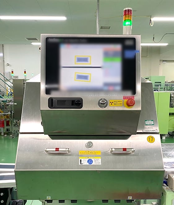 製造ラインに設置されたX線検査装置の操作画面を用いて、『熱さまシート』に不具合がないかを1枚ずつ確認している検査工程の様子