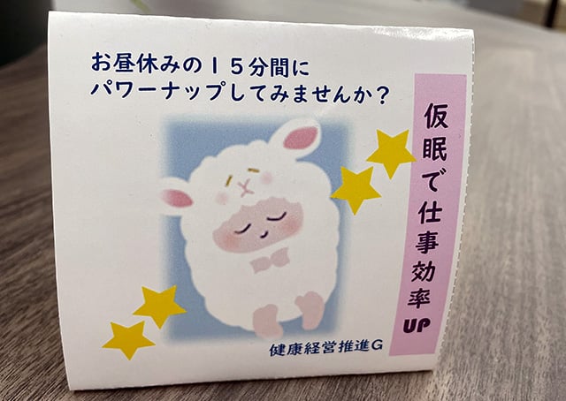 仮眠を推奨する卓上POP。かわいい羊のイラストとともに、「お昼休みの15分間にパワーナップしてみませんか?」「仮眠で仕事効率UP」と書かれている。